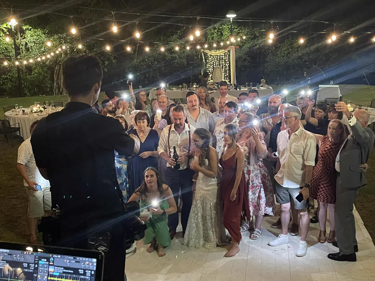 Newlyweds celebrating under fairy lights with guests
