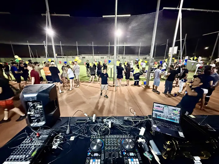 Crowd dancing on an outdoor deck at night