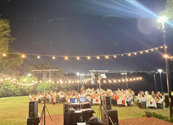Garden wedding reception under fairy lights at sunset