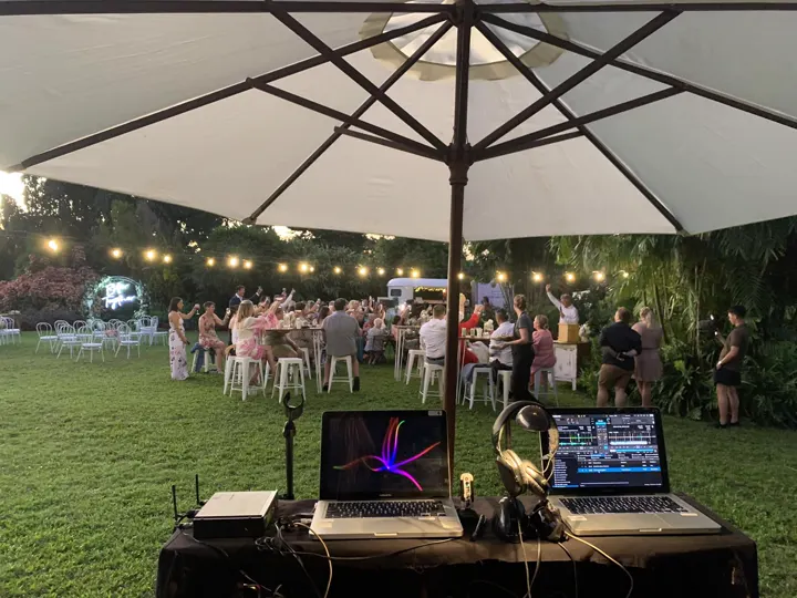 DJ set‑up under an umbrella in a garden