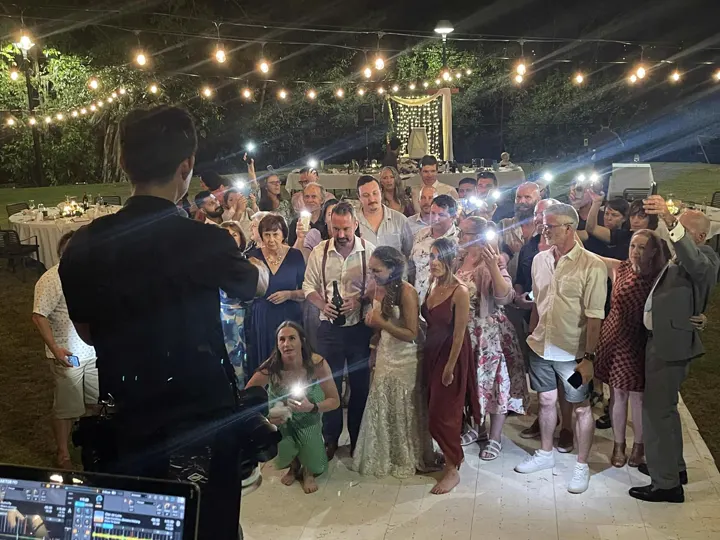 Wedding couple and guests under fairy lights